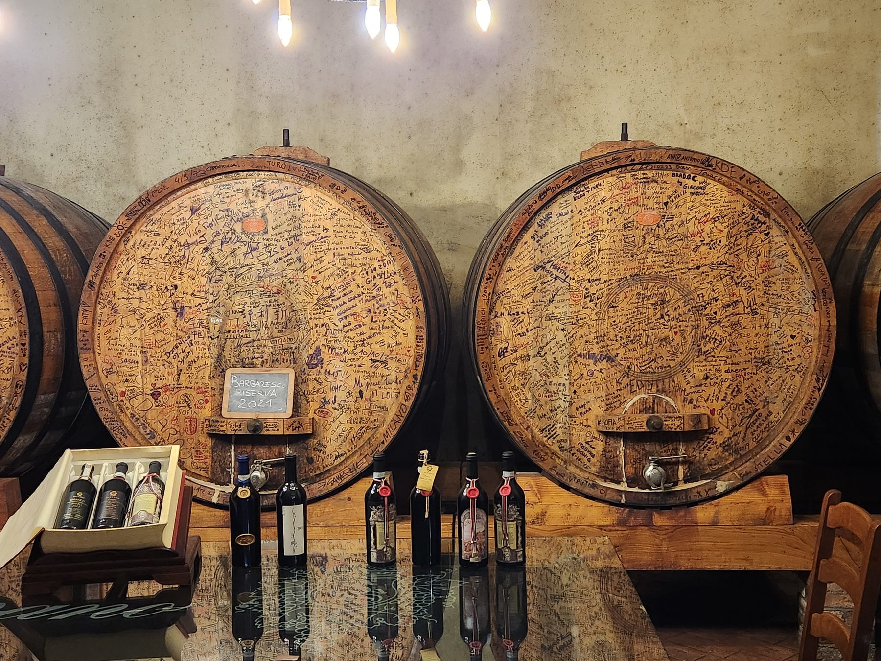 Grands foudres de bois couverts de signatures de visiteurs, cave d'un domaine du Barolo
