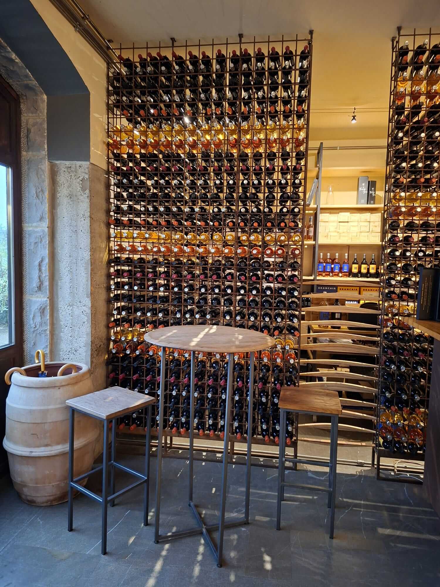Espace de dégustation de l'enoteca le domaine avec table haute et casiers