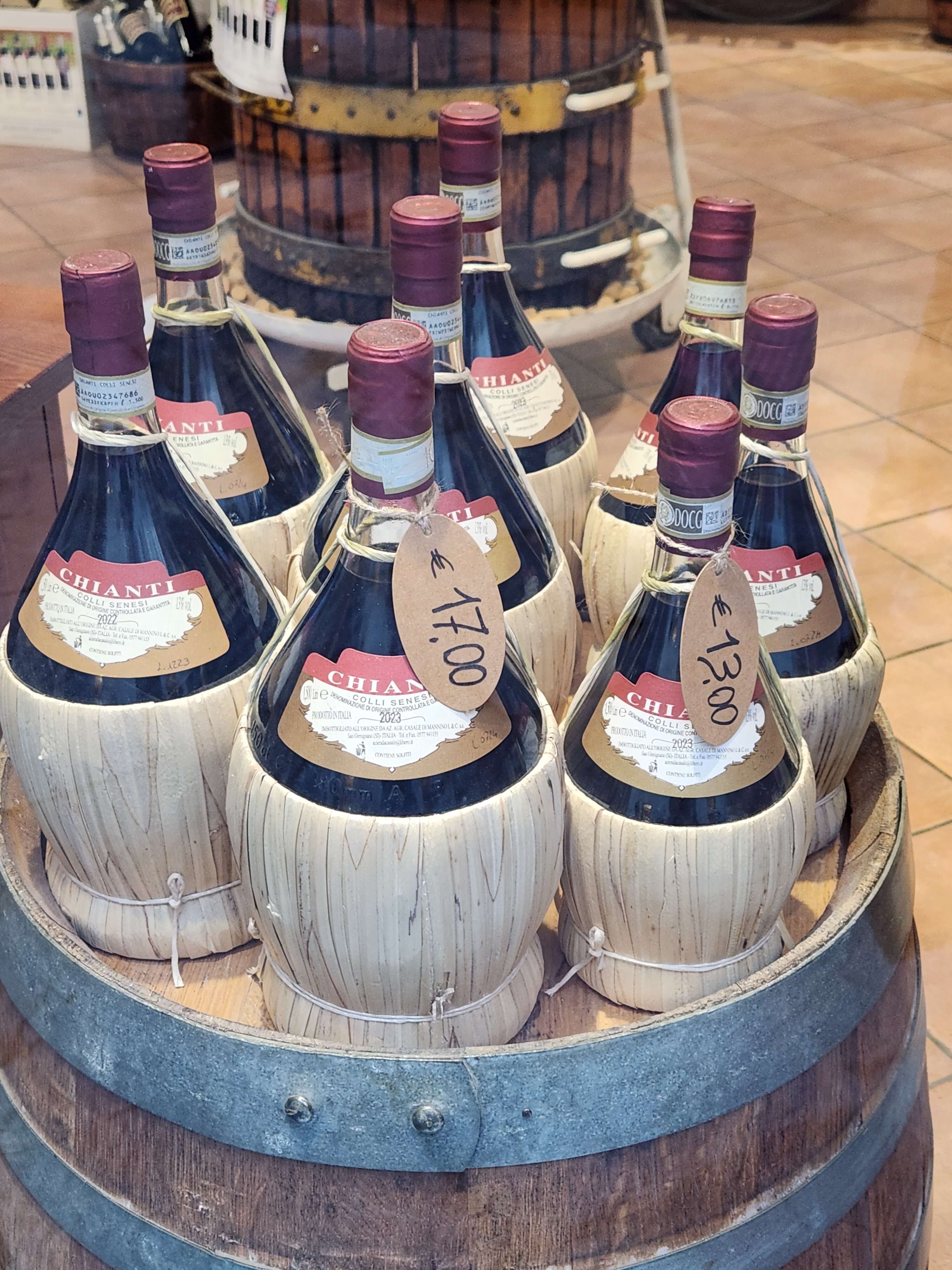 Fiasques de Chianti traditionnelles en paille sur un tonneau