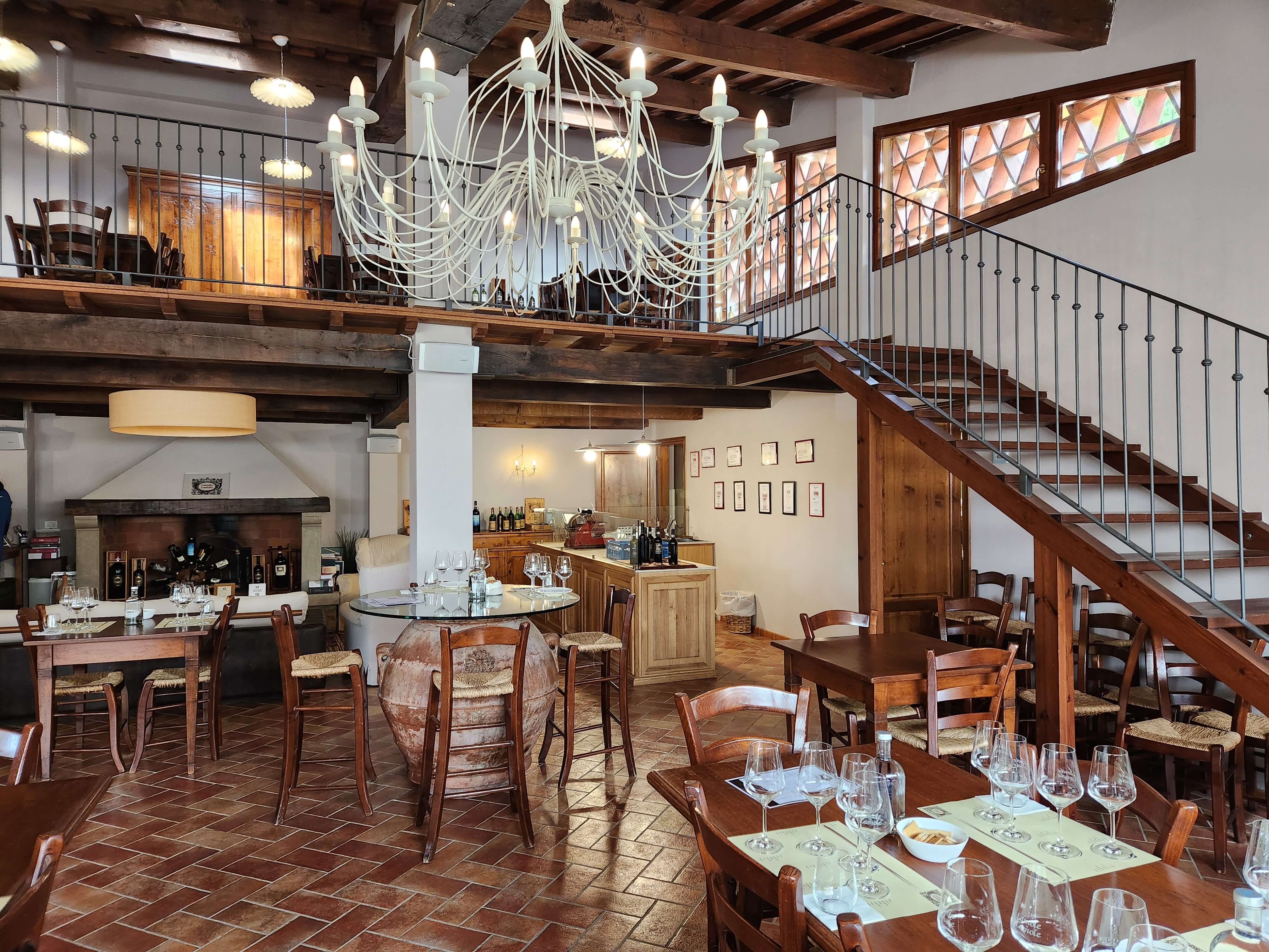 Salle de dégustation du domaine, ferme toscane avec poutres et lustre blanc