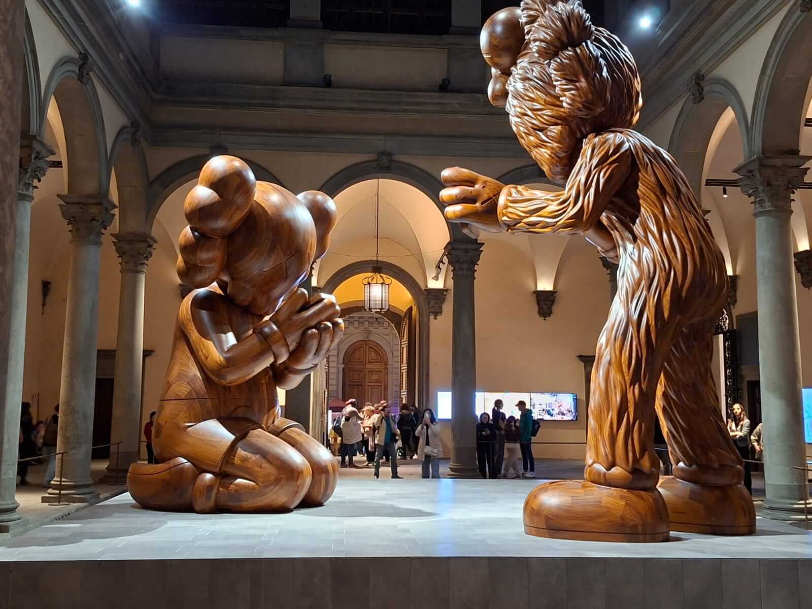 Exposition KAWS dans un palazzo florentin, sculptures en bois pop art dans une cour Renaissance