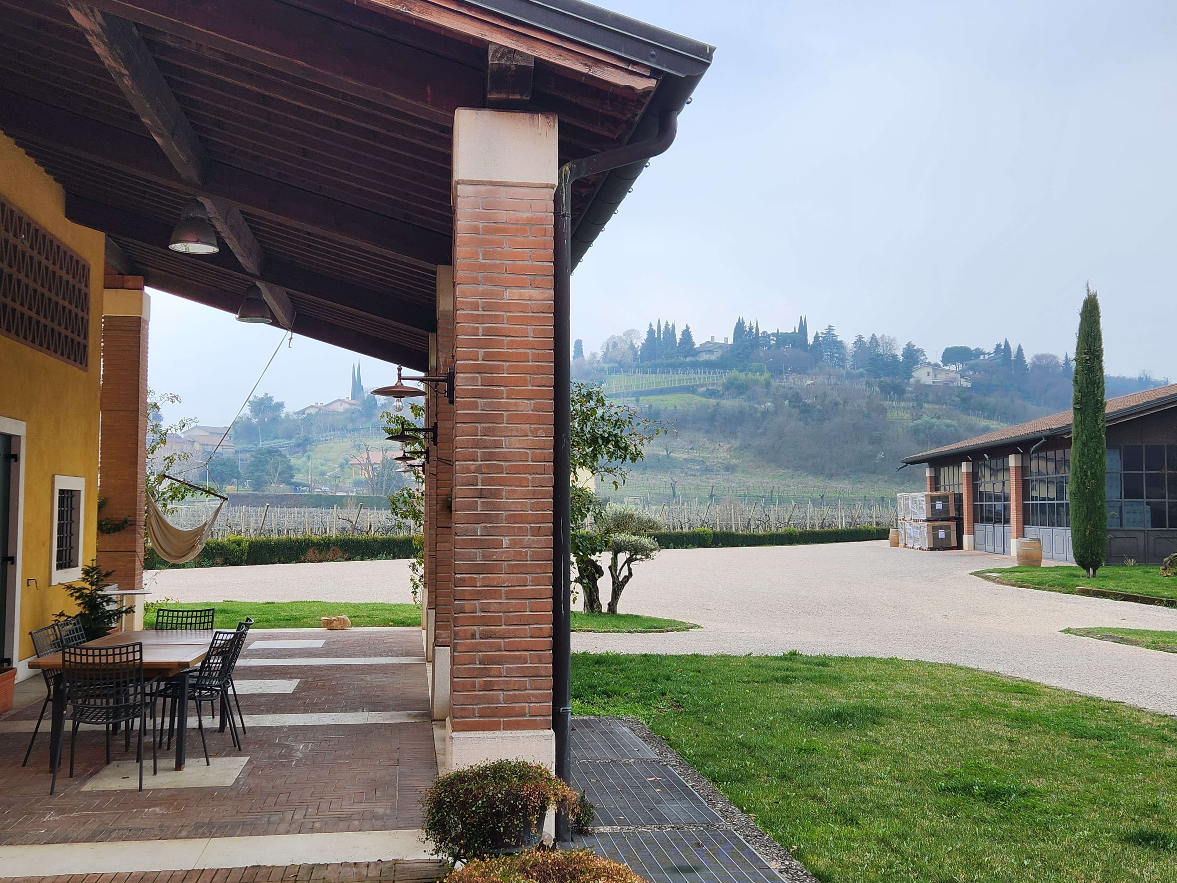 Terrasse d'un domaine en Valpolicella avec vue sur les collines viticoles, lac de Garde