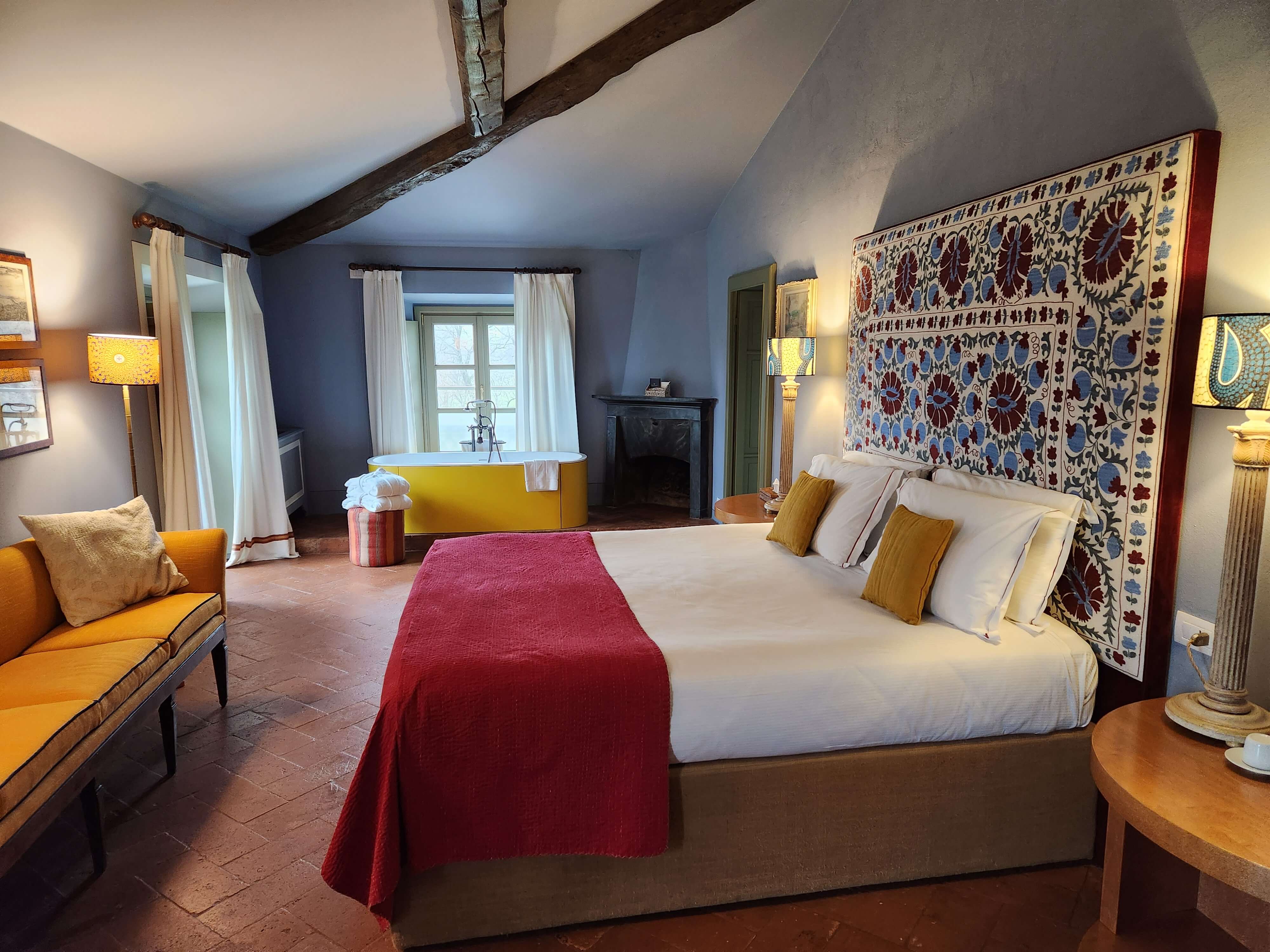 Chambre rustique d'un wine resort en Valpolicella, baignoire jaune et tête de lit brodée